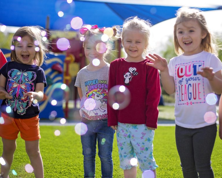 young girls playing with bubbles outside